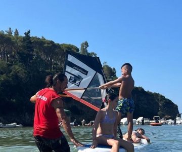 Bambini durante una lezione di windsurf sulla spiaggia del Camping Stella Mare a Lacona