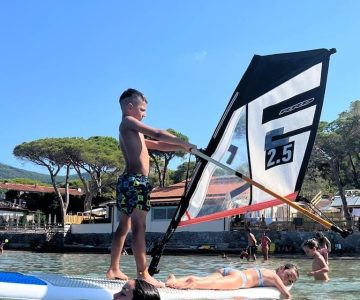 Bambini imparano il windsurf davanti al Camping Stella Mare a Lacona, Isola d’Elba